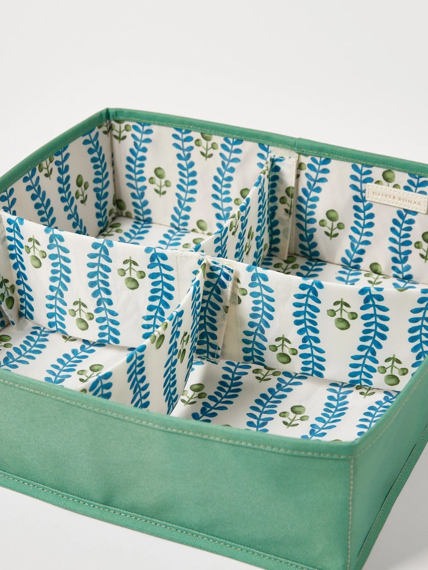 Green and blue patterned drawer organiser on a white table