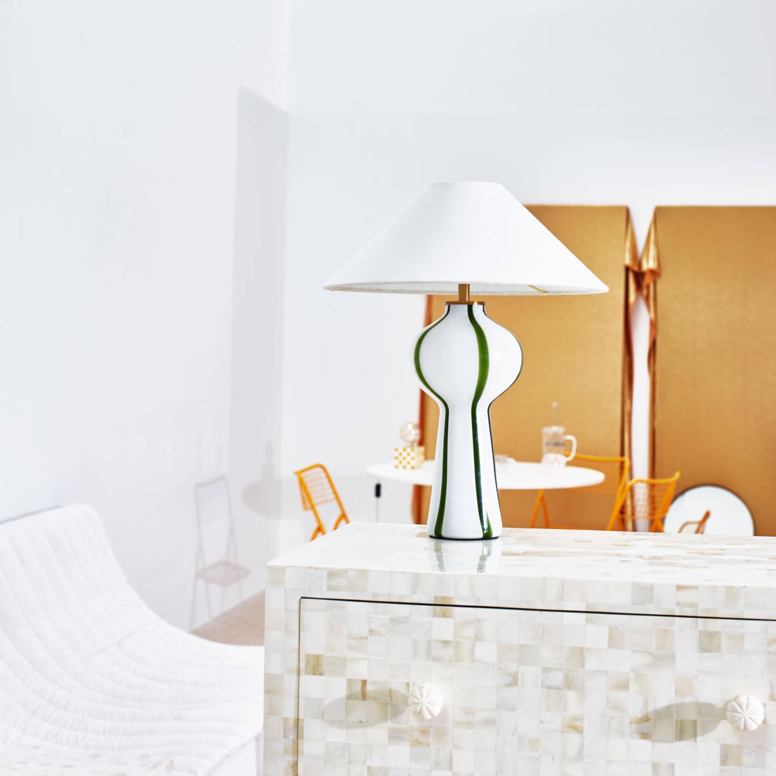 Stripy glass table lamp on a chequerboard chest of drawers 